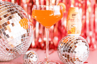 Skinny mixes Peach Ring with disco balls and a peach cocktail